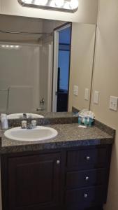 a bathroom with a sink and a large mirror at Instalodge Hotel and Suites Karnes City in Karnes City
