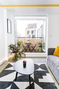 a living room with a couch and a table at Comfy & spacious Apt, 2 balconies, near the 02 arena, Greenwich in London