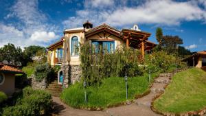 una casa en una colina con jardín en Llullu Llama Mountain Lodge, en Hacienda Provincia