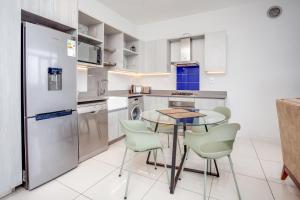 a kitchen with a table and chairs and a refrigerator at The Median in Rosebank in Johannesburg