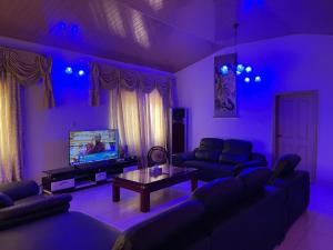 a purple living room with couches and a tv at AGASTEV Guesthouse GH in Accra