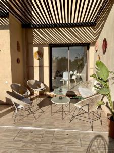 a patio with chairs and a table and a table and chairs at Villa BSF - Private Pool & Spa - Palm Golf in Marrakech