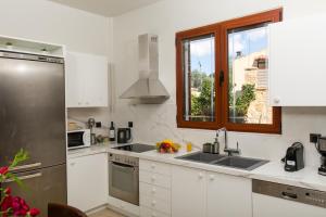 a white kitchen with a sink and a window at Grandpa's Exclusive Villa in Mixórrouma