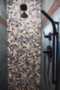 a bathroom with a shower with a tiled wall at The Sol Cottage+ Hiking+Creek Access+Views in Sedona