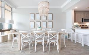a white dining room with a table and chairs at Phoenix Orange Beach II 2003 in Orange Beach