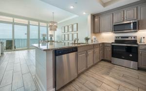 a kitchen with stainless steel appliances and a view of the ocean at Phoenix Orange Beach II 2003 in Orange Beach