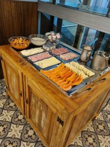 um buffet com queijo e outros alimentos sobre uma mesa em Hotel Pousada Clássica em Ouro Preto