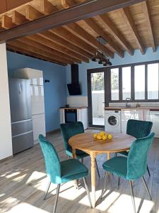 a kitchen and dining room with a wooden table and chairs at Grande maison de vacances in Perpignan