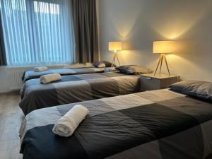 a hotel room with three beds with towels on them at Golden Pearl in Centre of Brussels in Brussels