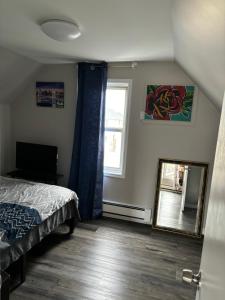 1 dormitorio con cama, espejo y ventana en Van Buren Gem 2.0, en Newark