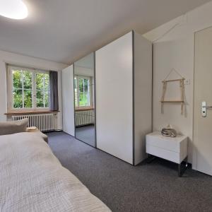 a bedroom with a white bed and a mirror at peaceful tiny house near forest in Rorschacherberg