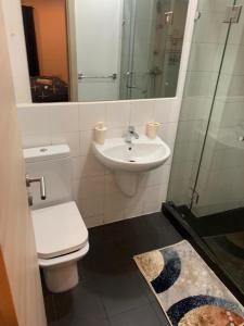 e bagno con servizi igienici, lavandino e doccia. di CityView Apartment a Accra