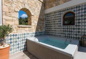 a bathroom with a bath tub in a stone wall at Grandpa's Exclusive Villa in Mixórrouma