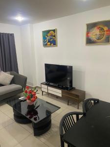 un soggiorno con divano e TV di CityView Apartment a Accra