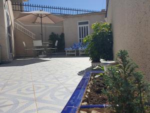 eine Terrasse mit einem Sonnenschirm, einem Tisch und Stühlen in der Unterkunft El Caprichito a 200 metros de la playa! in Santiago de la Ribera