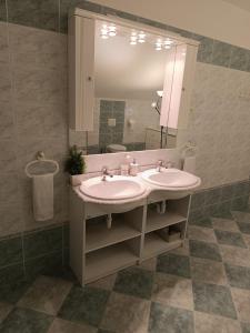 uma casa de banho com 2 lavatórios e um espelho grande em Garden villa em Budapeste