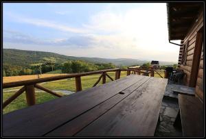 una mesa de picnic de madera en un porche con vistas en Świety Spokój, en Paleśnica