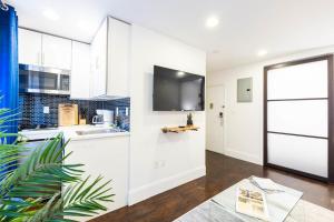 a kitchen with white cabinets and a large window at 69-4C PRIME Lower East Side 1br Apt Brand New in New York