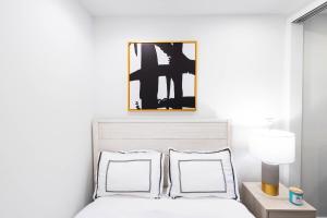 łóżko z dwoma poduszkami i zdjęciem nad nim w obiekcie 69-4C PRIME Lower East Side 1br Apt Brand New w Nowym Jorku