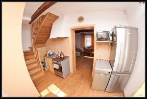 uma cozinha com um frigorífico de aço inoxidável e uma escada em Świety Spokój em Paleśnica