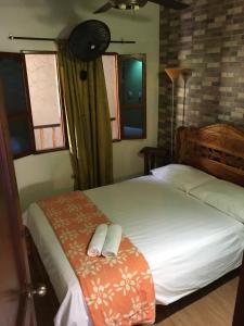 a bedroom with two beds with towels on them at Hostal Los Wichos in Minca