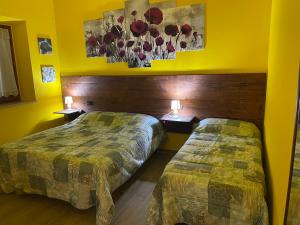 2 camas en una habitación con paredes amarillas en A casa di Bice, en Case Nuove