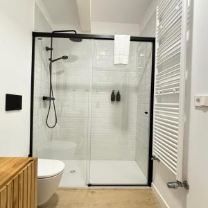 uma casa de banho com uma cabina de duche em vidro e um WC. em NOiTE 1 em Pontevedra