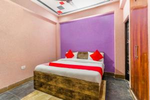 a bedroom with a bed with red and purple walls at OYO Mastic Marvell in Noida