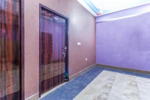 an empty room with a door with purple walls at OYO Mastic Marvell in Noida