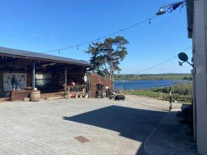 un grand bâtiment avec un lac en arrière-plan dans l'établissement McCormacs Farmhouse, à Mullanalaghta