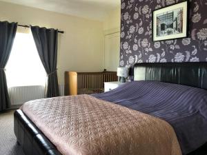 a bedroom with a bed with a purple comforter at McCormacs Farmhouse in Mullanalaghta