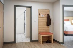 Schlafzimmer mit einem Bett, einem Stuhl und einem Spiegel in der Unterkunft Candlewood Suites - Lexington - Medical District, an IHG Hotel in Lexington