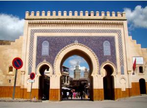 a building with an arch with a city in the background at Dar Dahab in Fez