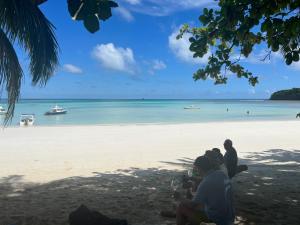 un grupo de personas sentadas en una playa en Superbe villa avec ponton privé, en Andilana