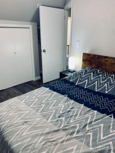 a bedroom with a bed with a blue and white bedspread at Van Buren Gem 2.0 in Newark +7 photos