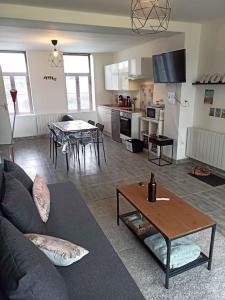 een woonkamer met een bank en een tafel bij Le Perchoir in Saint-Jans-Cappel