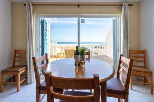 a dining room with a table and a view of the ocean at Apartamento Meia Praia in Lagos