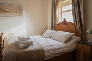 een slaapkamer met een bed met witte lakens en een raam bij The Plough Inn in Snaith