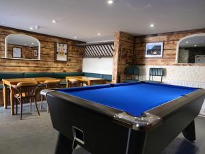 uma mesa de bilhar num bar com mesas e cadeiras em The Plough Inn em Snaith