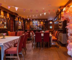 een eetkamer met tafels en stoelen en een bar bij The Plough Inn in Snaith