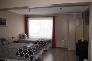 a bedroom with two beds and a window at HOTEL LOYOLA in Coihaique