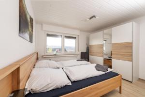 2 camas en una habitación con 2 ventanas en FeWo Freiken 28 en Arnsberg