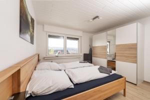 Dos camas en una habitación con dos ventanas. en FeWo Freiken 28, en Arnsberg