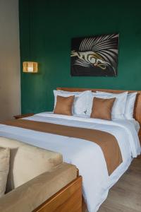 a large bed in a room with a green wall at Jetian villa in Nusa Lembongan