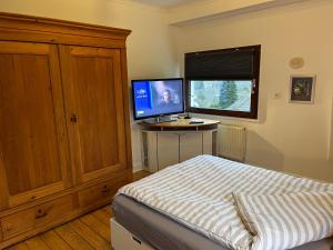 Schlafzimmer mit einem Bett und einem Schreibtisch mit einem Computermonitor in der Unterkunft Ferienhaus Brinker Bleibe in Velbert