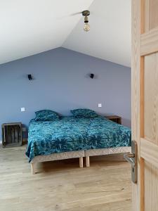 een slaapkamer met een bed met een blauwe deken bij Grande maison de vacances in Perpignan