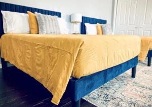 a blue bed with a yellow blanket on it at Windmill Inn in Abilene