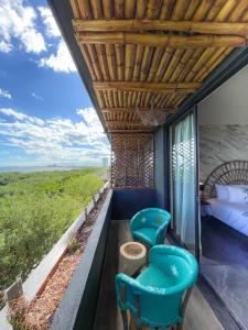 Habitación con balcón con 1 cama y 2 sillas. en Akuazul Resorts Adults Only en Cancún