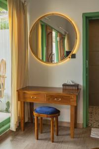a wooden dressing table with a mirror and a stool at Jetian villa in Nusa Lembongan