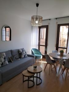 sala de estar con sofá, mesa y sillas en Apartamentos Rúa Centro Calatayud & Balcony Apartament, en Calatayud